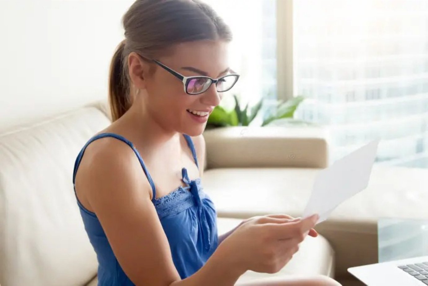 A woman smiling while reading a letter