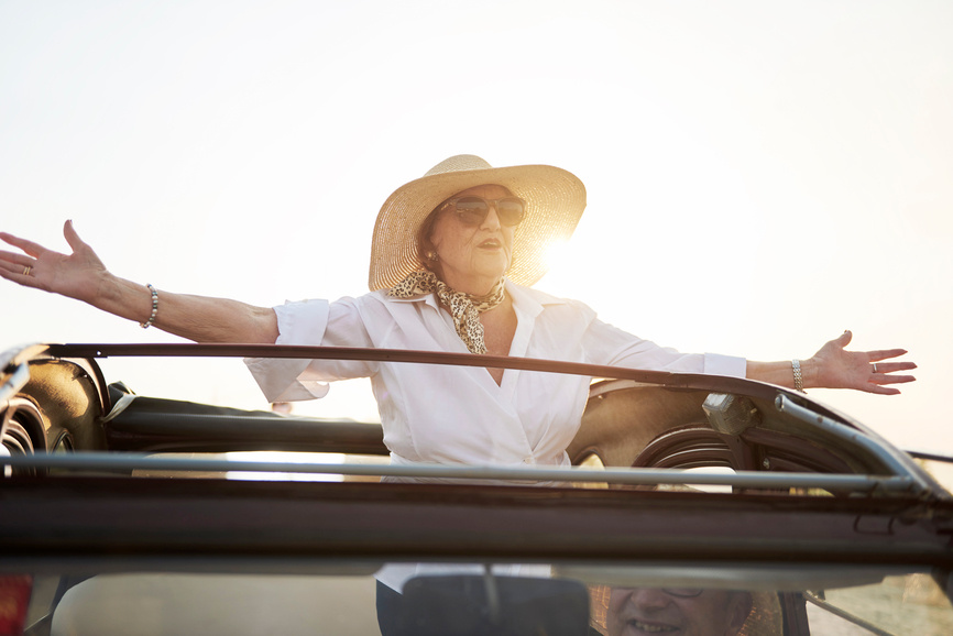 Grandma riding in a car with arms open